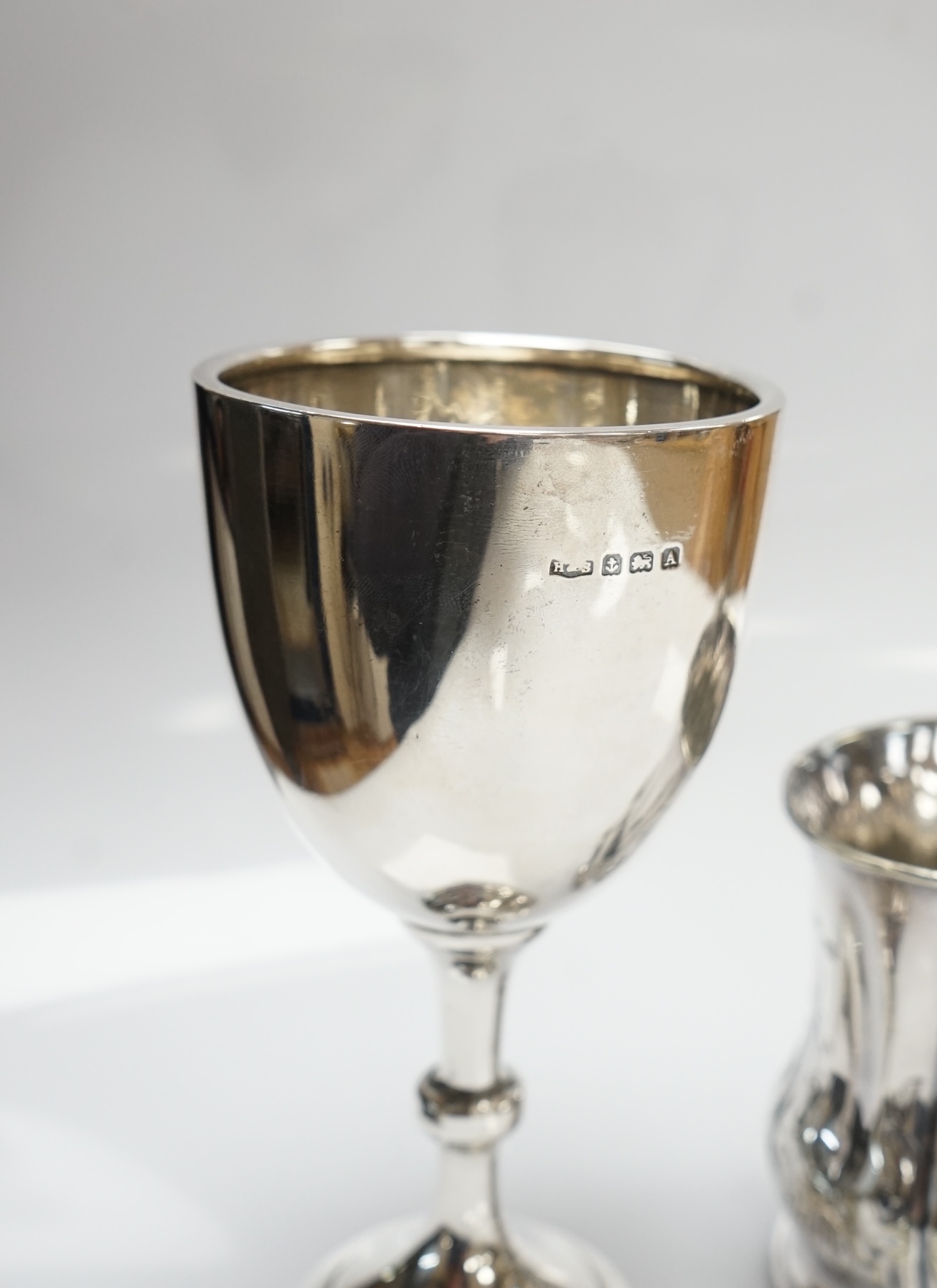 A George V silver goblet, Harrison & Sons, Birmingham, 1925, 15.3cm and a silver plated christening mug. Condition - fair